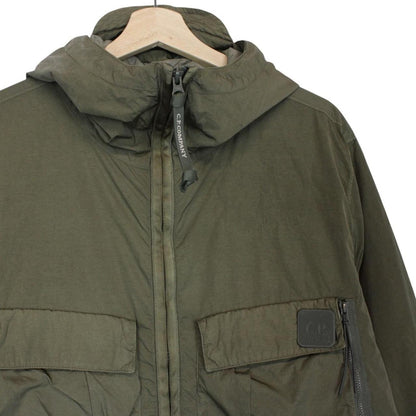 CP Company green hooded jacket with chrome detailing and logo patch on sleeve.