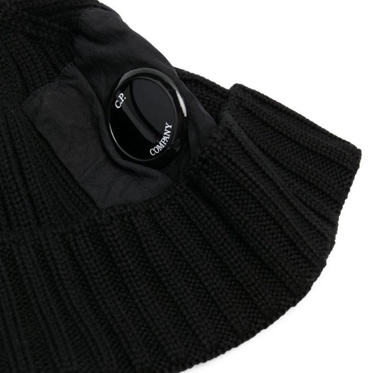 CP Company black beanie hat made of extra fine merino wool with side lens detail.