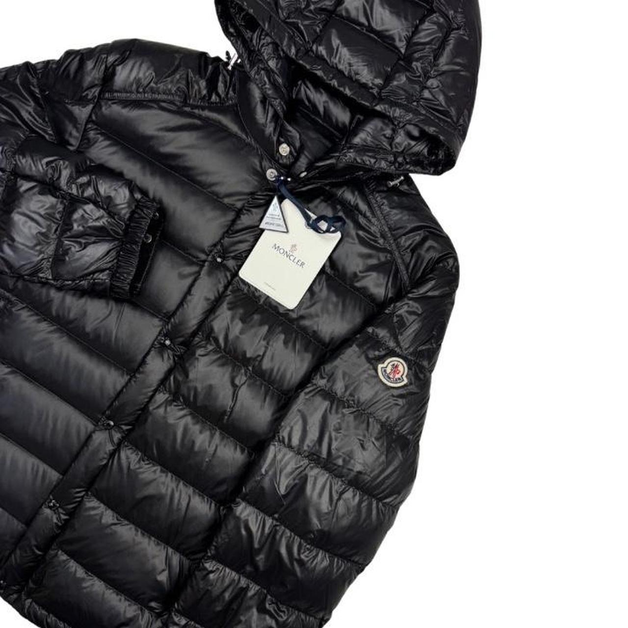 Moncler black hooded puffer jacket with logo patch and nylon material.