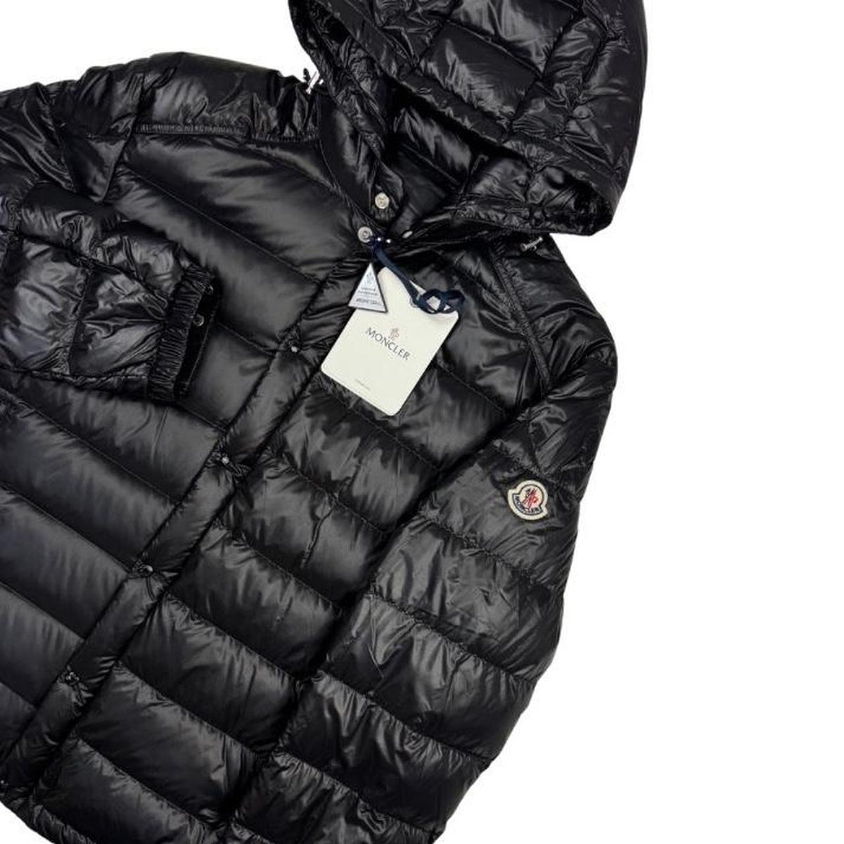Moncler black hooded puffer jacket with logo patch and nylon material.