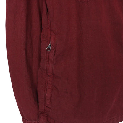 CP Company burgundy jacket with goggle detail and full zip closure.