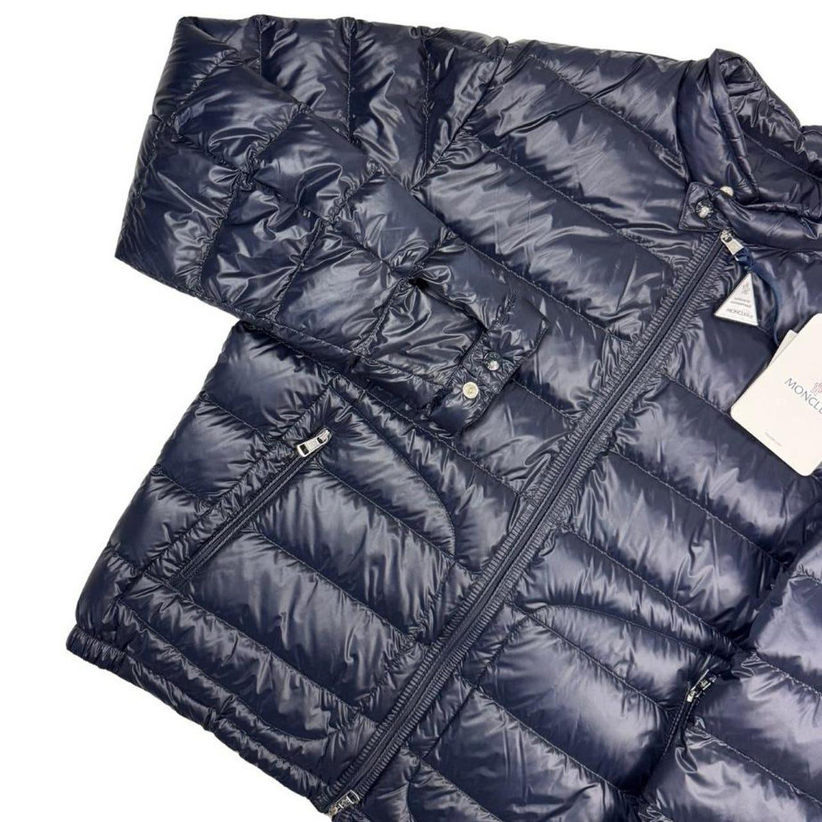 Moncler navy blue down jacket with full zip and logo patch on sleeve.