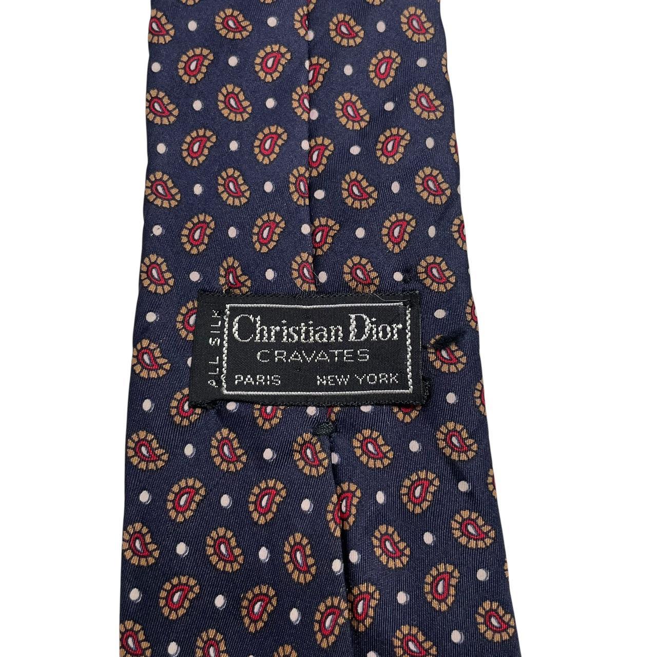 Christian Dior navy blue silk tie with paisley print pattern and logo detail.
