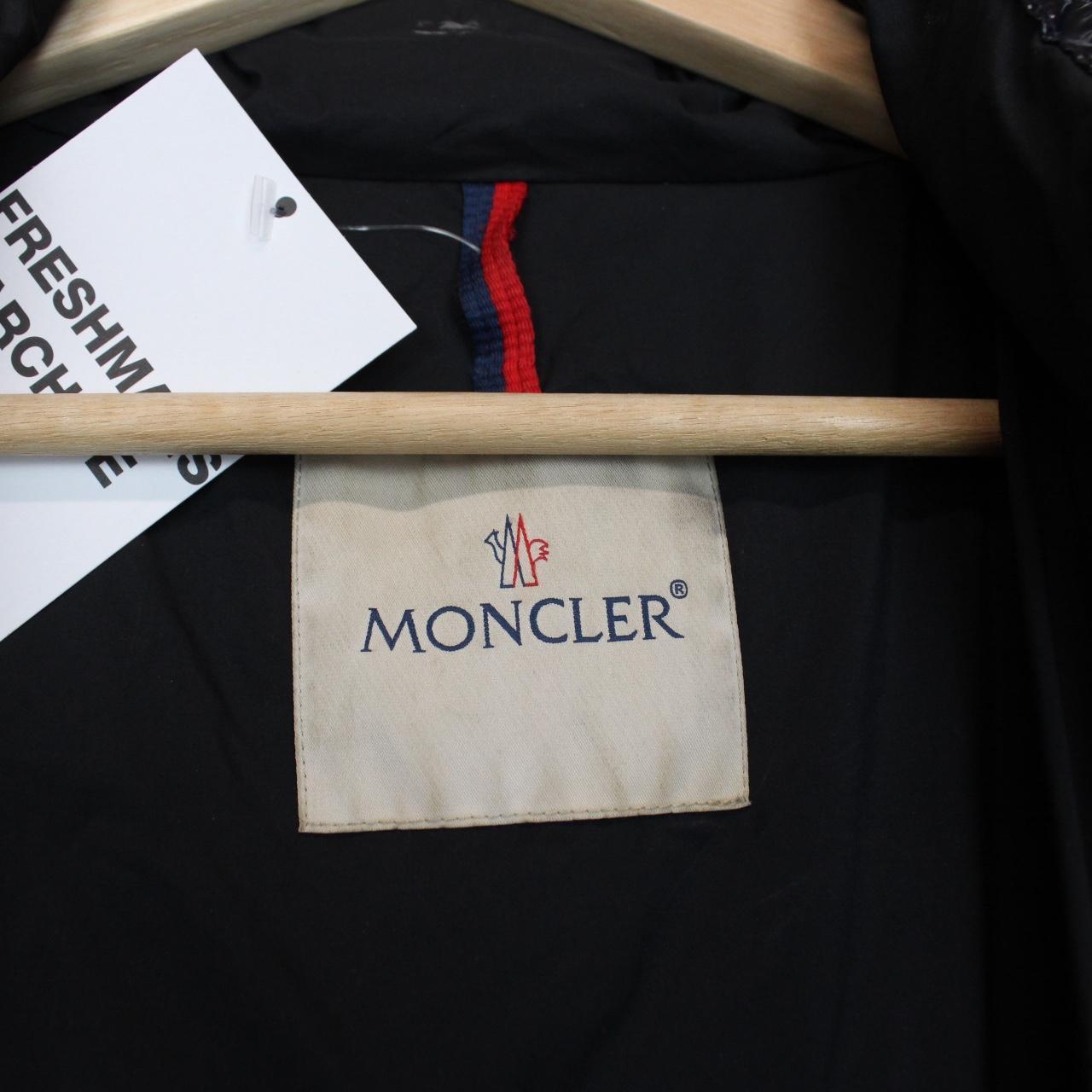 Moncler navy blue full zip down jacket with logo patch and quilted material.