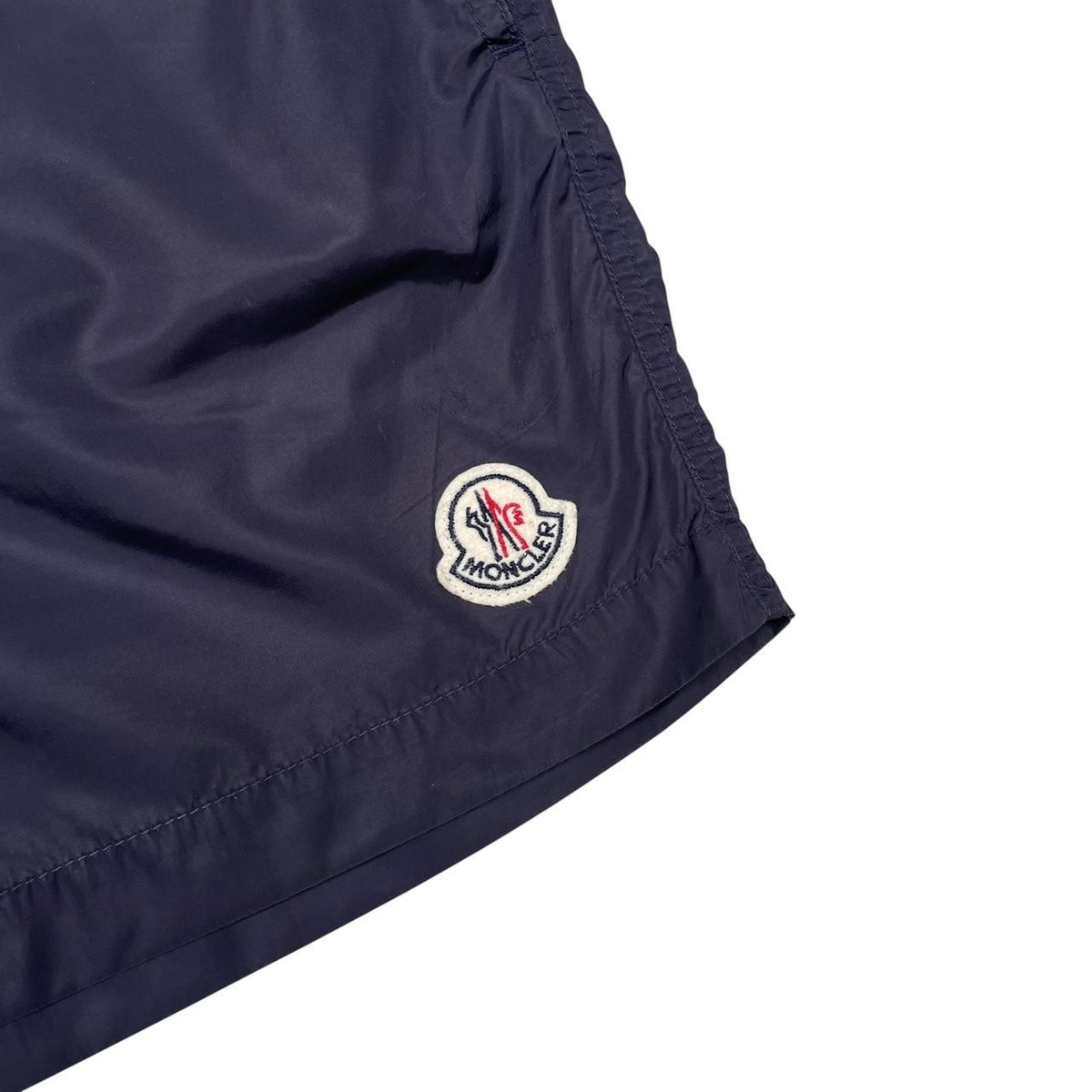 Moncler navy blue swim shorts with logo patch and lightweight nylon material.