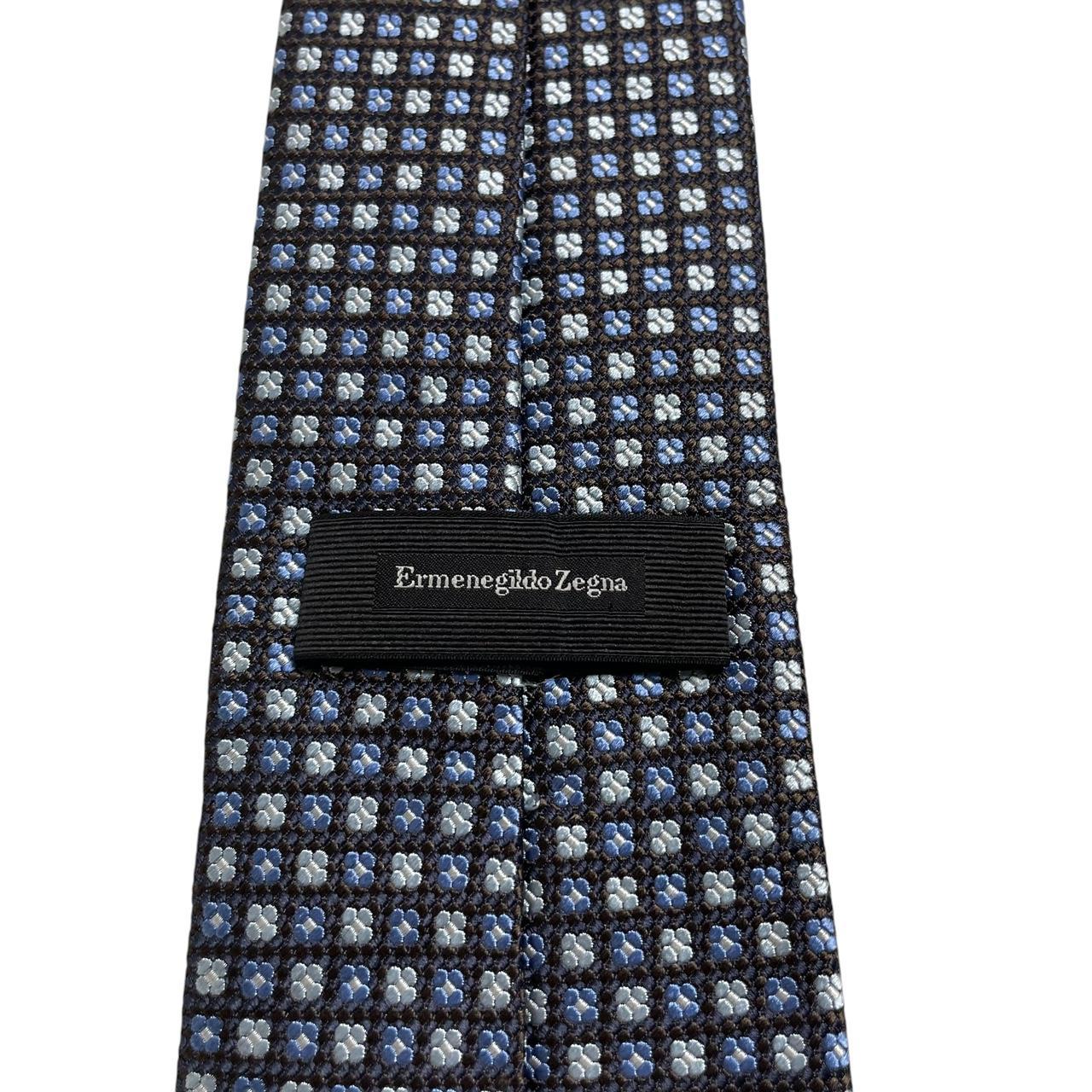 Ermenegildo Zegna blue silk tie with subtle sheen and logo detail.