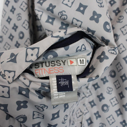 Stüssy reversible nylon jacket in grey and navy blue with logo detailing.