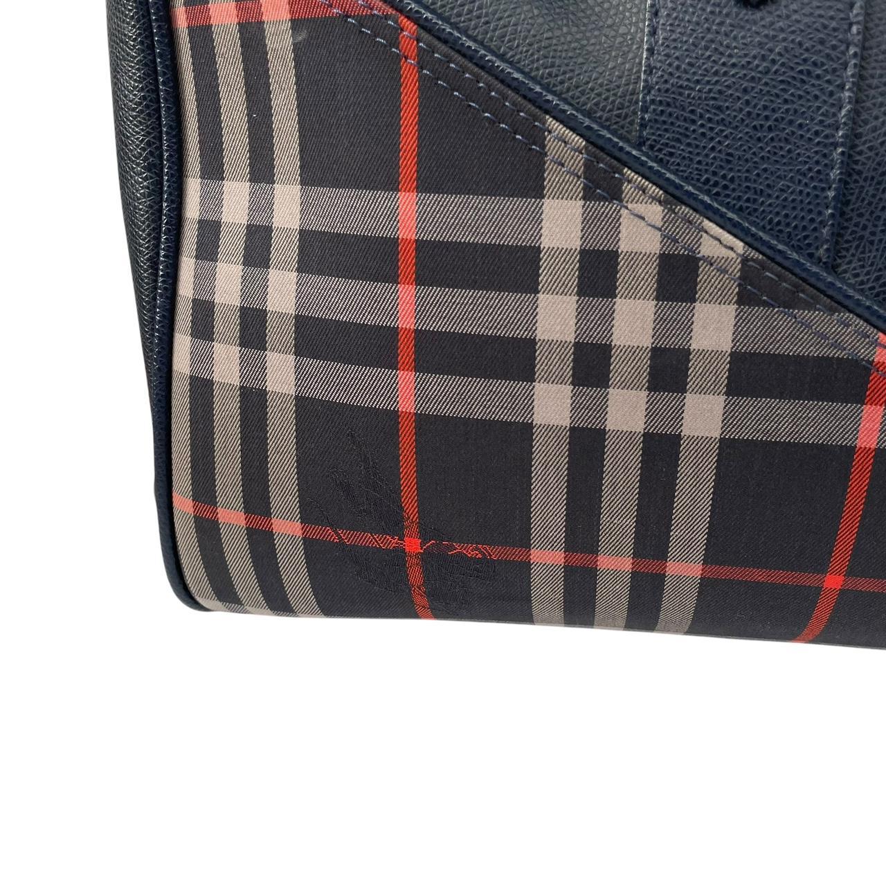 Burberry navy blue duffel bag featuring iconic Nova Check pattern and leather accents.