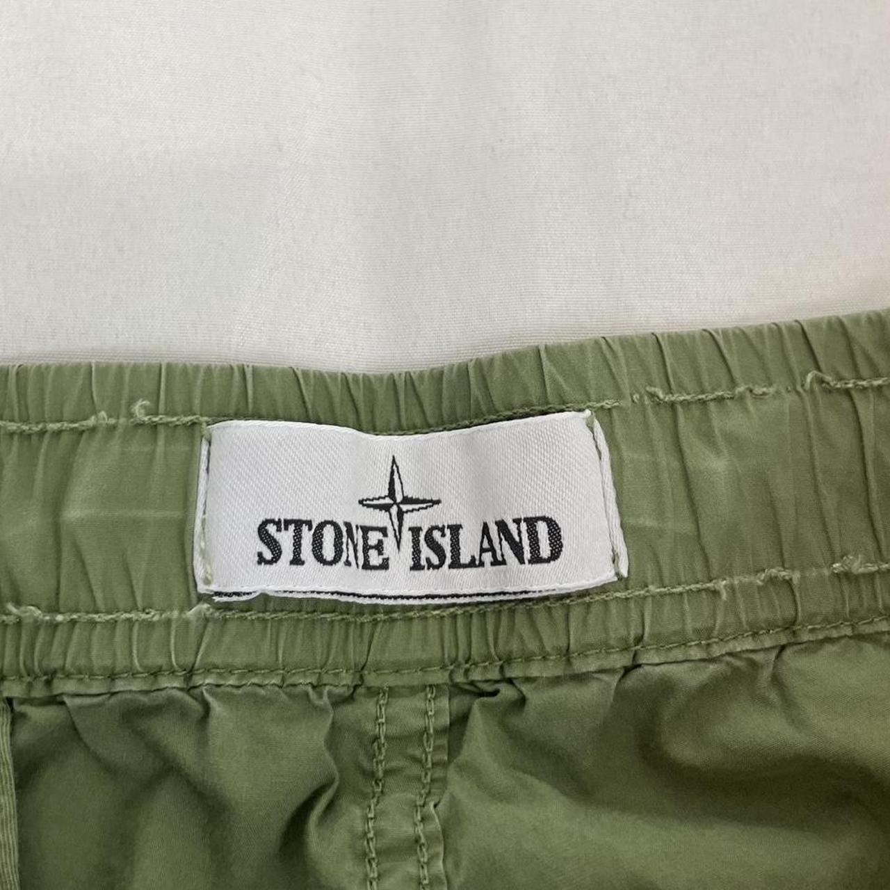 Stone Island green cargo trousers with logo patch and multiple pockets.