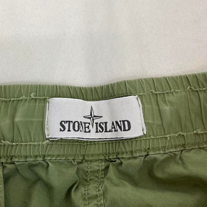 Stone Island green cargo trousers with logo patch and multiple pockets.
