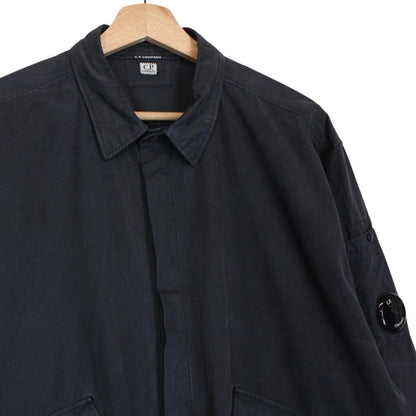 CP Company navy blue overshirt jacket with diamond pattern and lens detail.