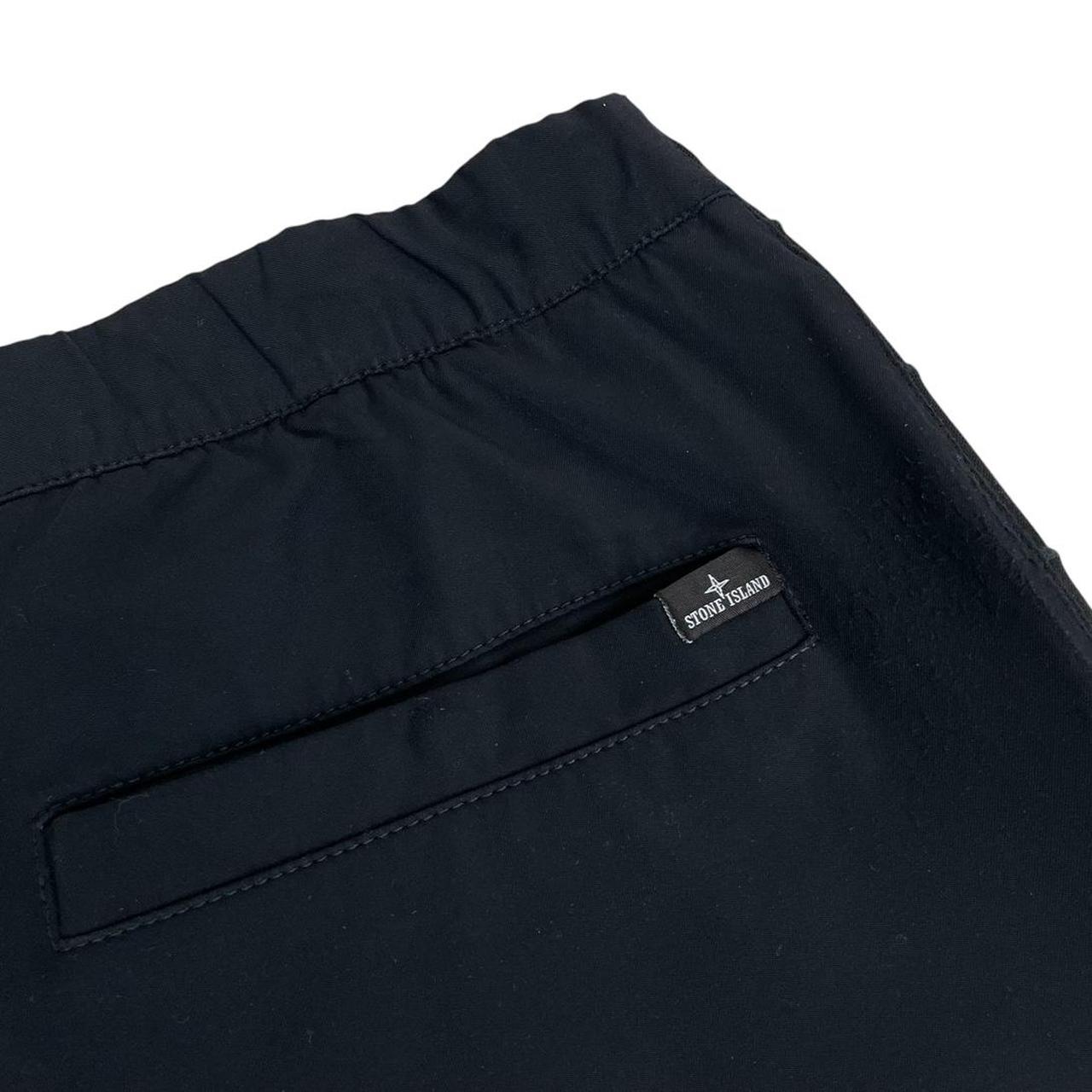 Stone Island navy blue joggers with logo patch and nylon material.