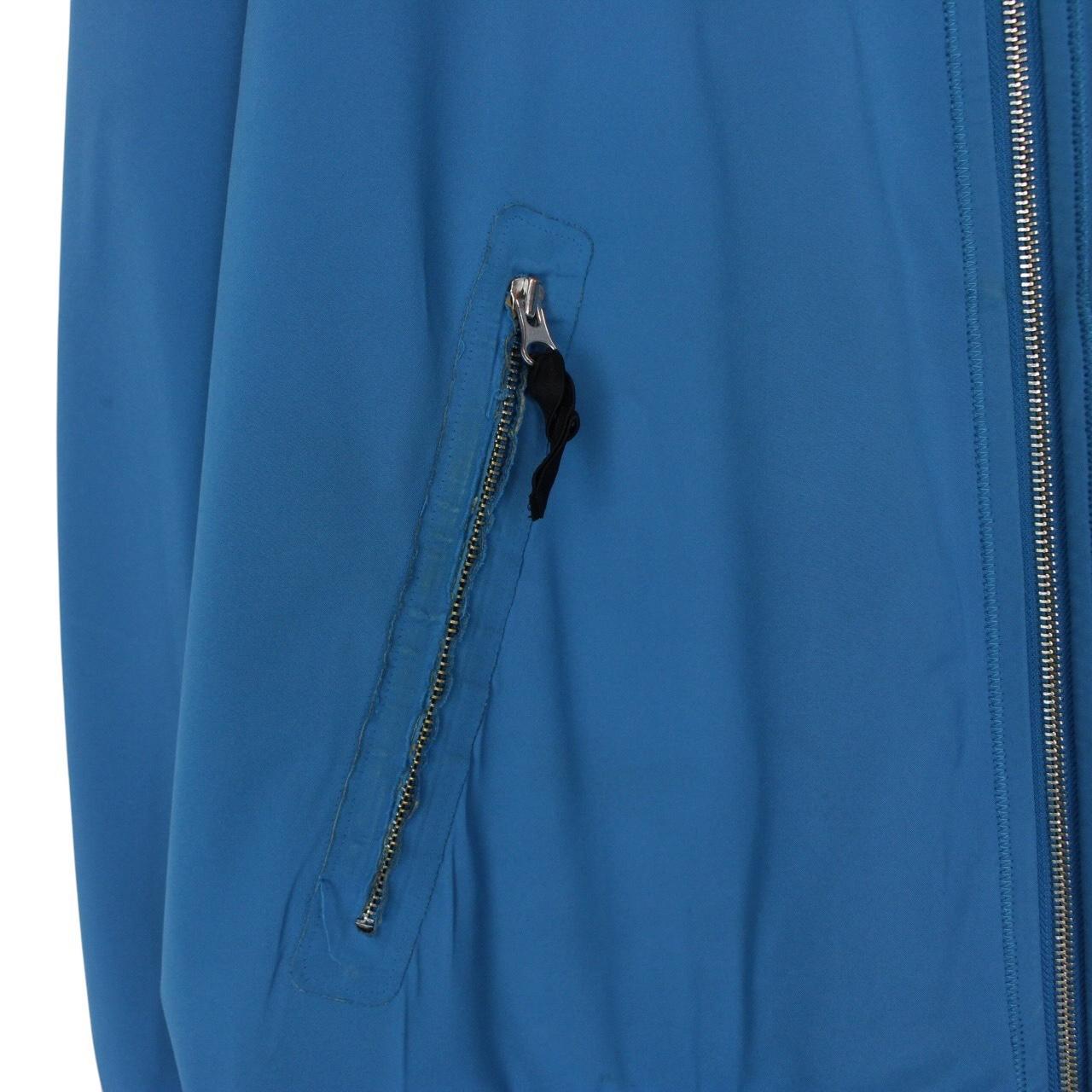 Stone Island blue full zip jacket with logo patch and soft shell material.