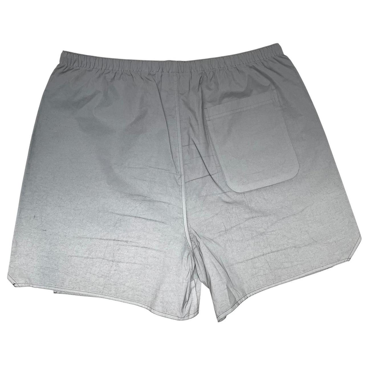 Essentials silver reflective nylon shorts with logo detail and sleek design.