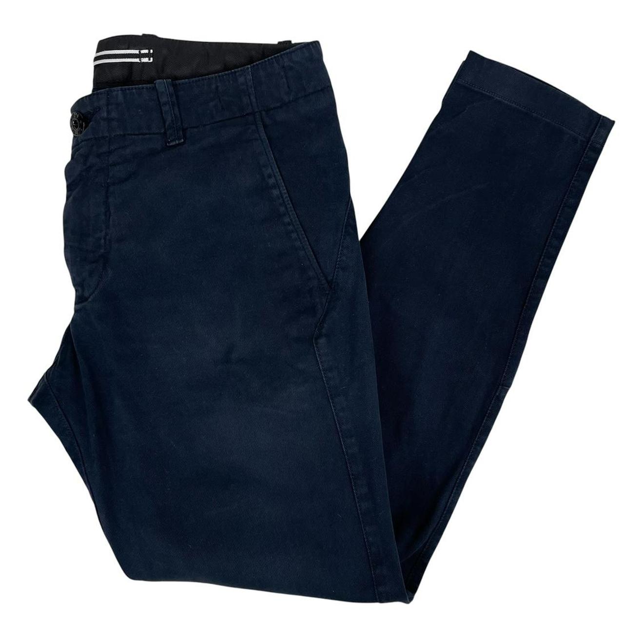 Stone Island navy blue skinny fit cotton trousers with logo patch and subtle wear.