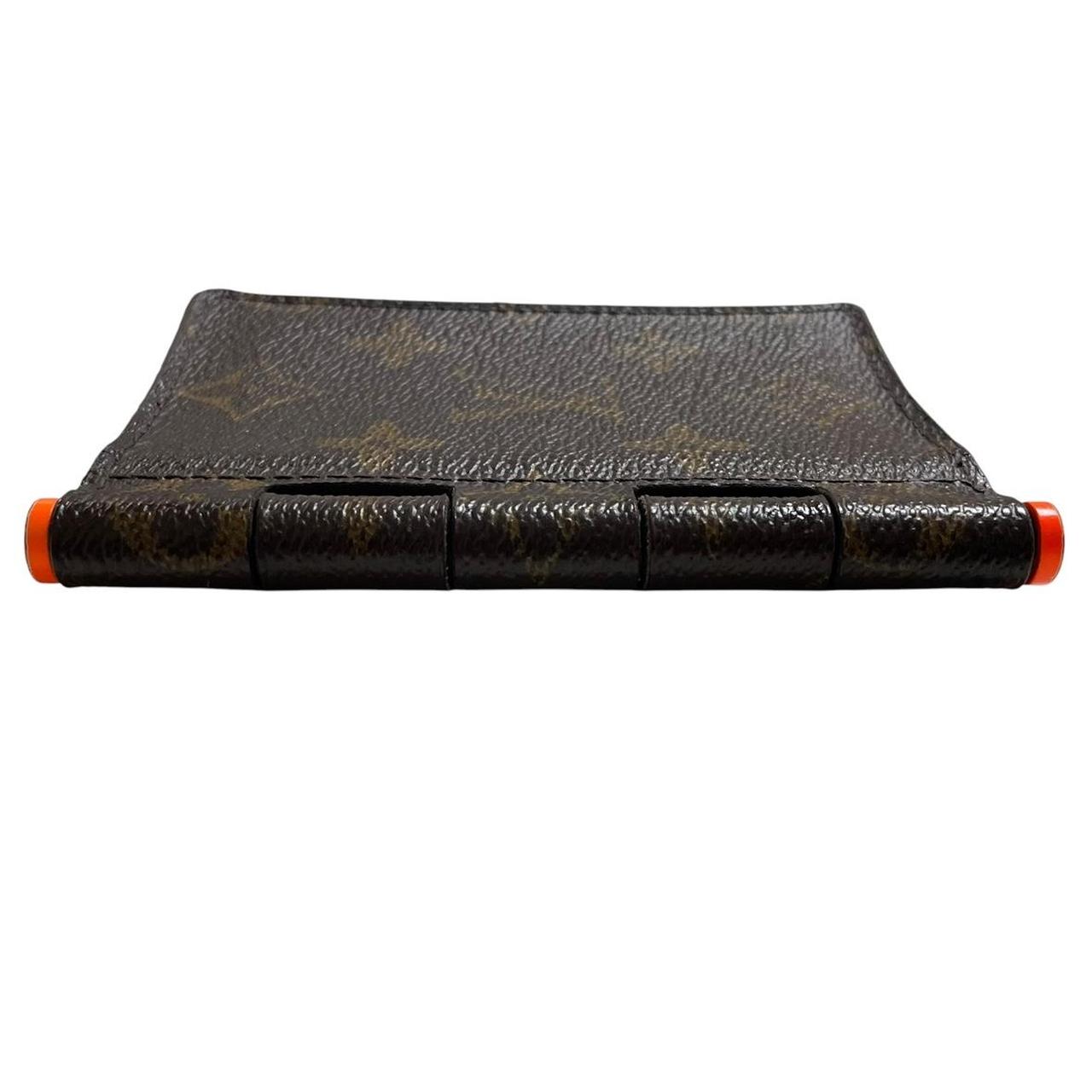 Louis Vuitton brown purse with orange metal hardware and iconic monogram pattern.