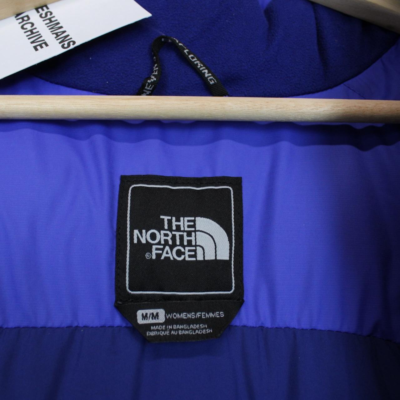 The North Face blue down gilet with logo detail and quilted pattern.