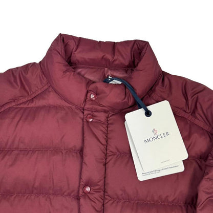 Moncler burgundy quilted down jacket with logo patch and shell material.
