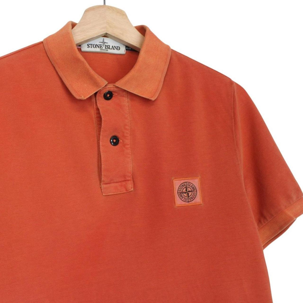 Stone Island orange short sleeve polo shirt with compass logo and cotton material.