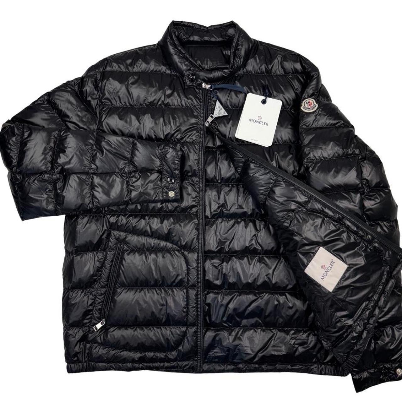 Moncler black nylon down jacket with full zip and logo patch on sleeve.