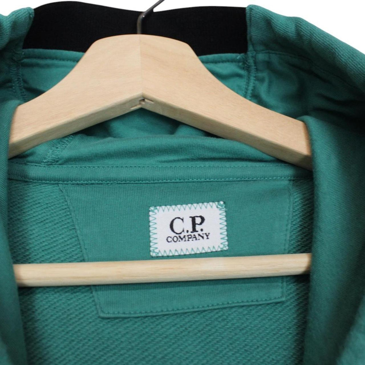 CP Company green hoodie jumper with lens detail and cotton material.