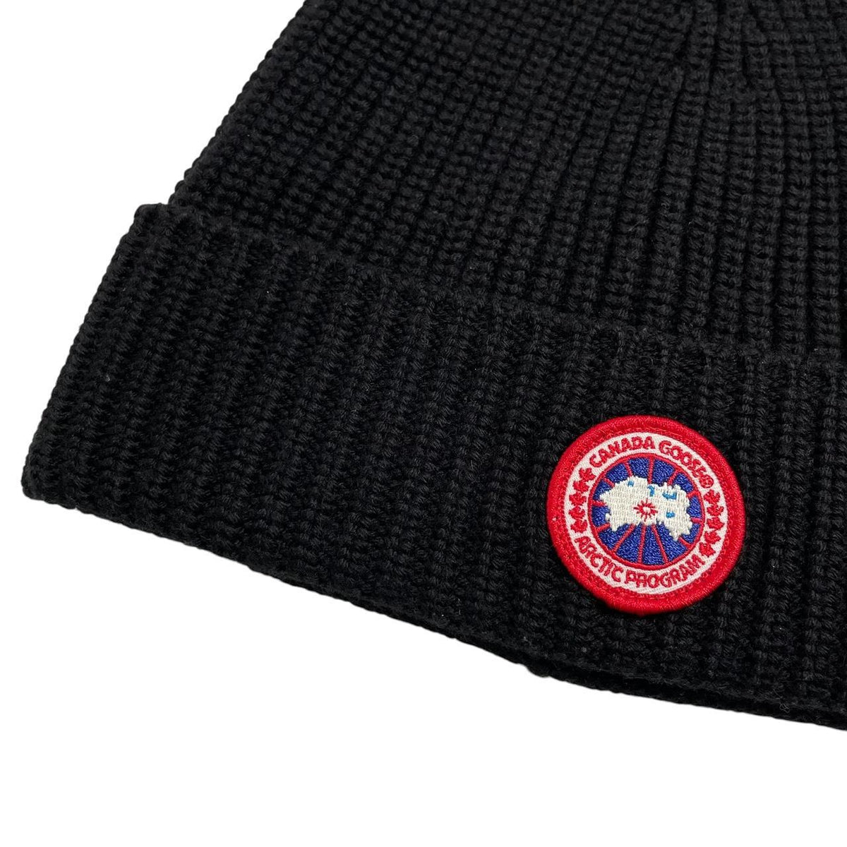 Canada Goose black ribbed wool beanie hat with logo patch on front.
