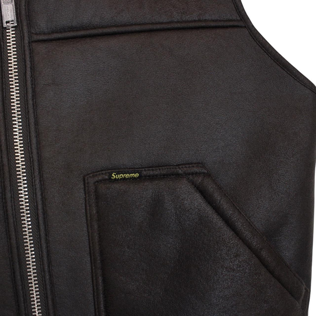 Supreme brown reversible faux shearling work vest with logo patch and textured fabric.