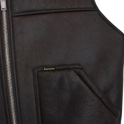 Supreme brown reversible faux shearling work vest with logo patch and textured fabric.
