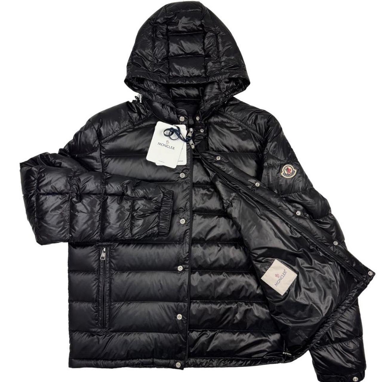 Moncler black hooded puffer jacket with logo patch and nylon material.