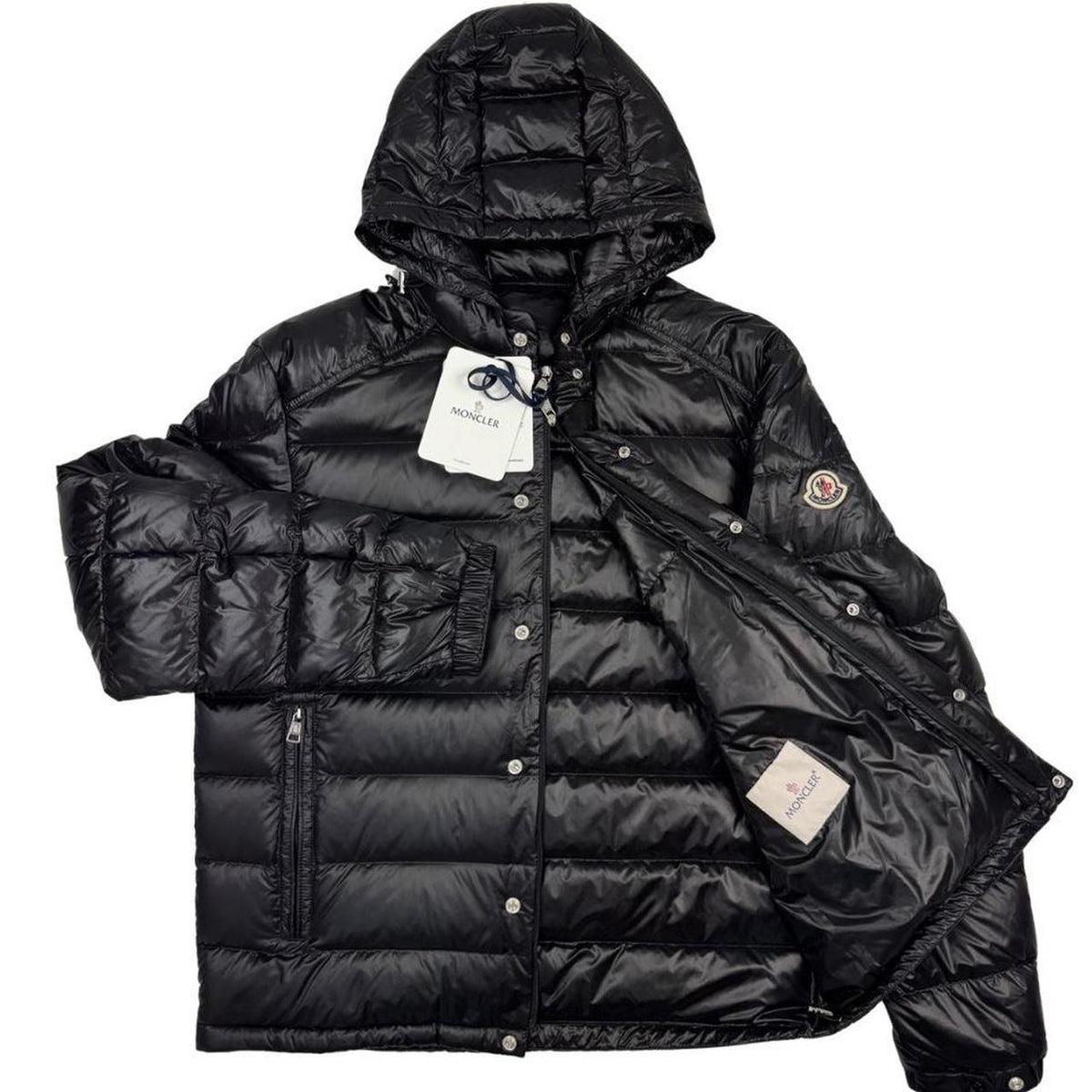 Moncler black hooded puffer jacket with logo patch and nylon material.