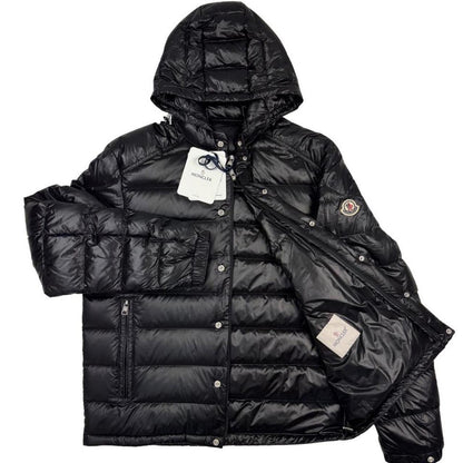 Moncler black hooded puffer jacket with logo patch and nylon material.