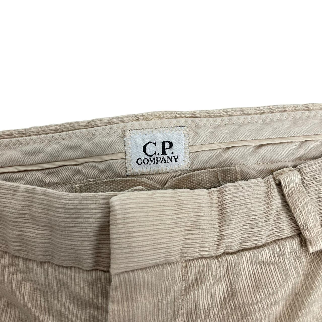CP Company beige ribbed cotton trousers with faint stains and regular fit design.