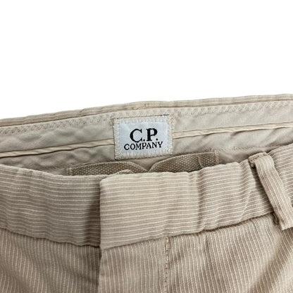 CP Company beige ribbed cotton trousers with faint stains and regular fit design.