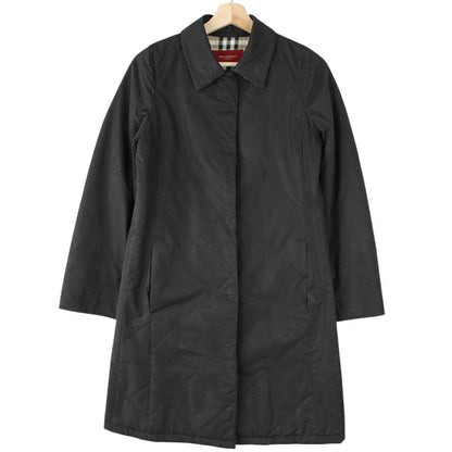 Burberry black trench coat featuring Nova Check pattern and quilted fabric.