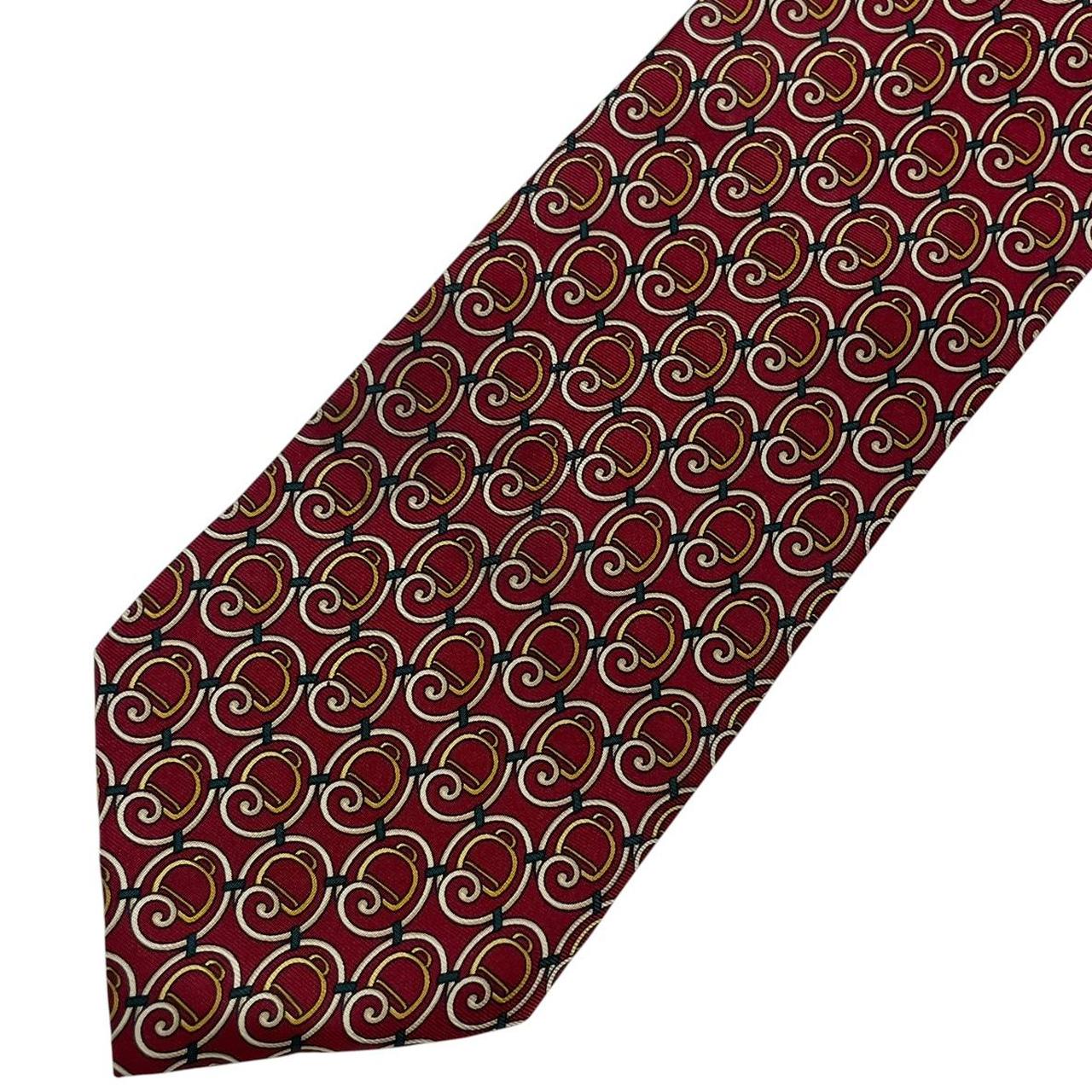 Gucci burgundy silk tie with vintage pattern and signature logo detail.