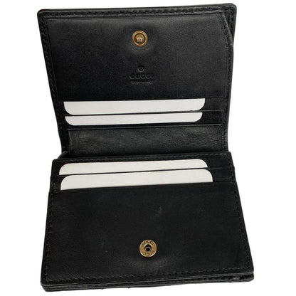 Gucci black calfskin wallet with matelassé pattern and GG logo detail.