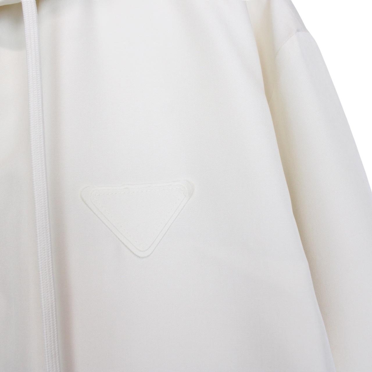 Prada cream silk hooded jacket with triangle logo and full zip detail.