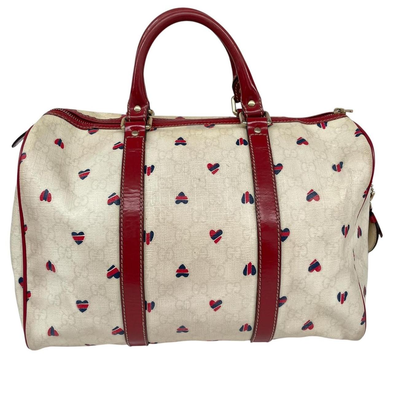 Gucci cream duffel bag with red monogram heart print and logo detailing.