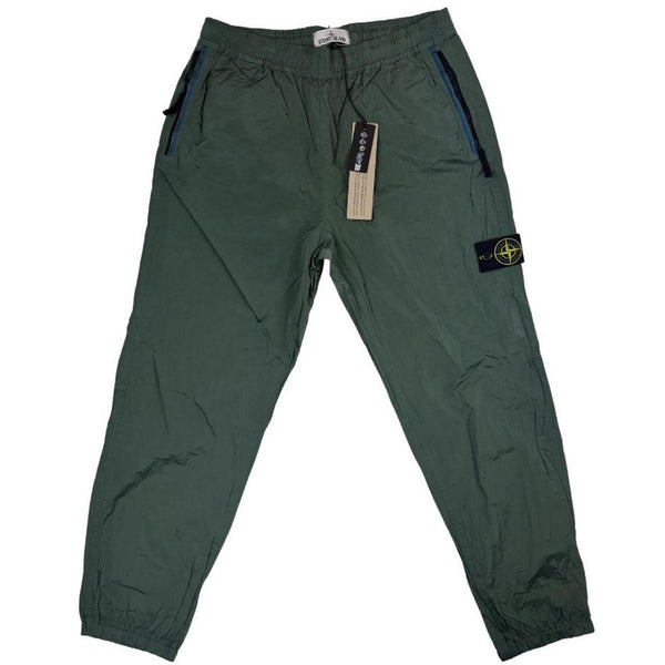 Stone Island green nylon metal trousers with logo patch and sleek finish.
