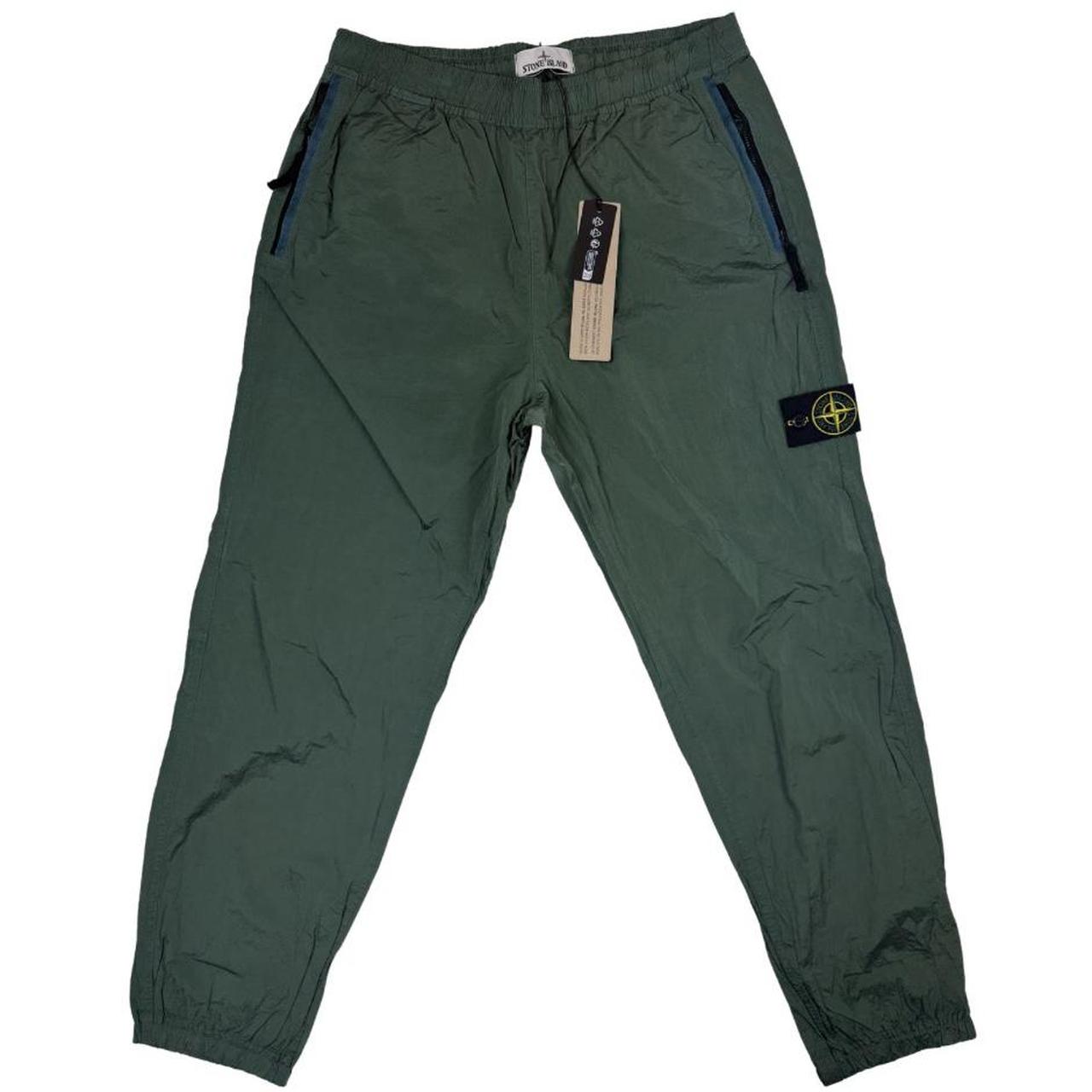 Stone Island green nylon metal trousers with logo patch and sleek finish.