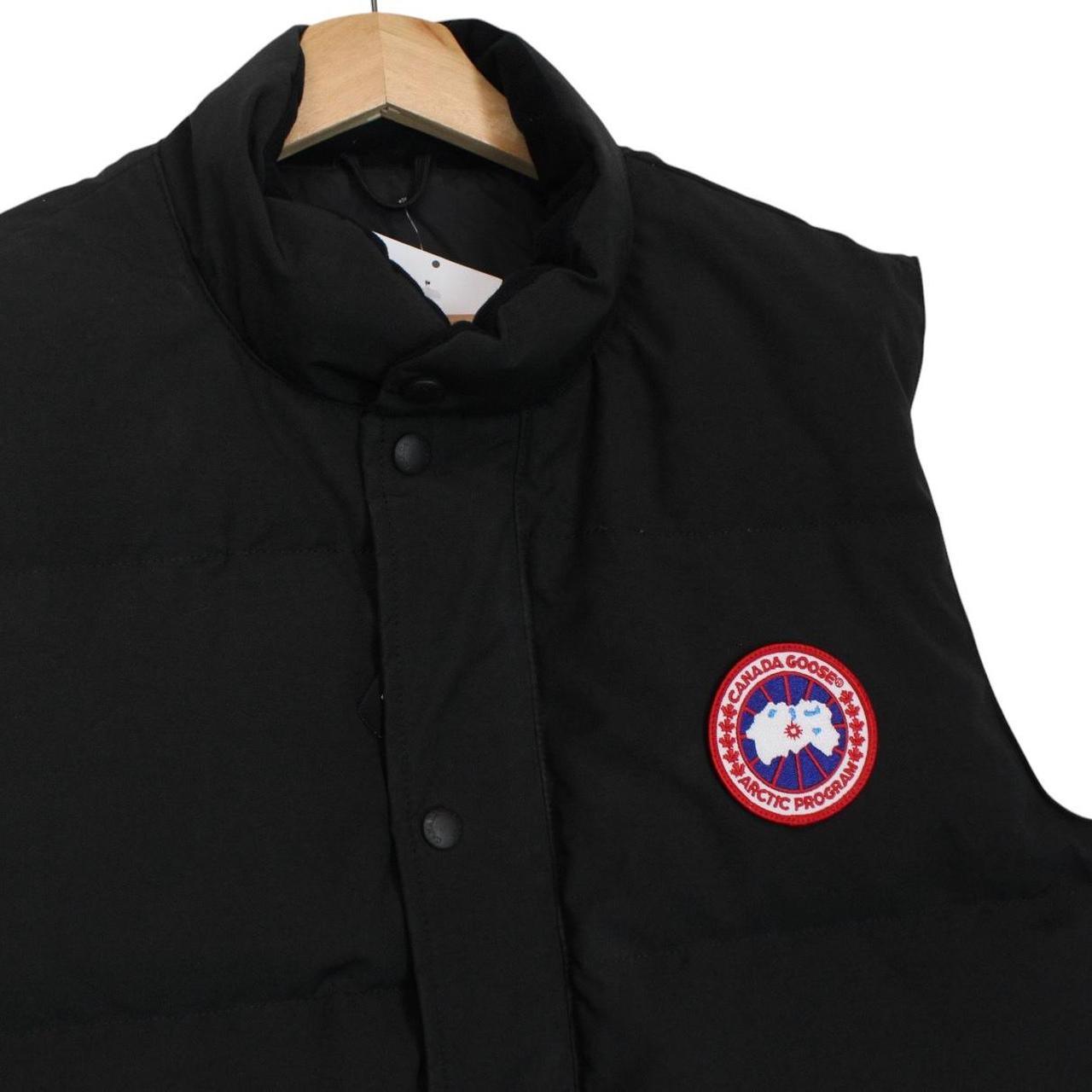 Canada Goose black down gilet with logo patch and zippered pockets.