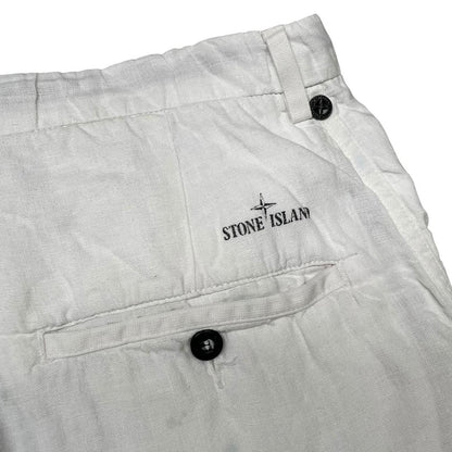Stone Island white linen Bermuda shorts with logo patch and subtle stains.