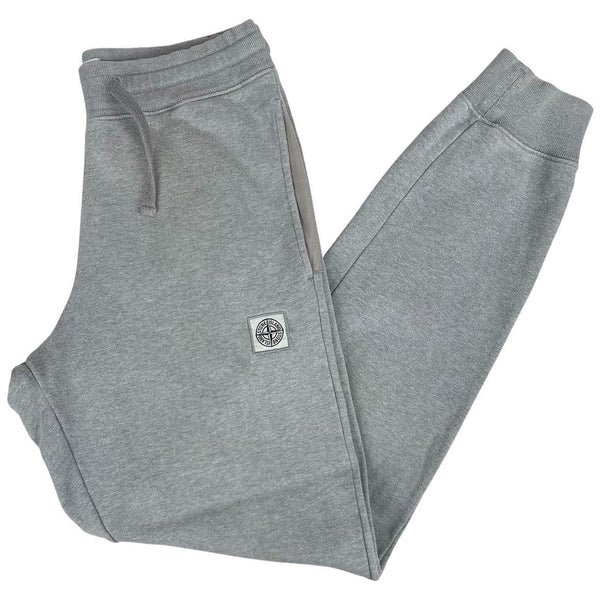 Stone Island grey tracksuit bottoms cotton material with logo patch and faint marks.
