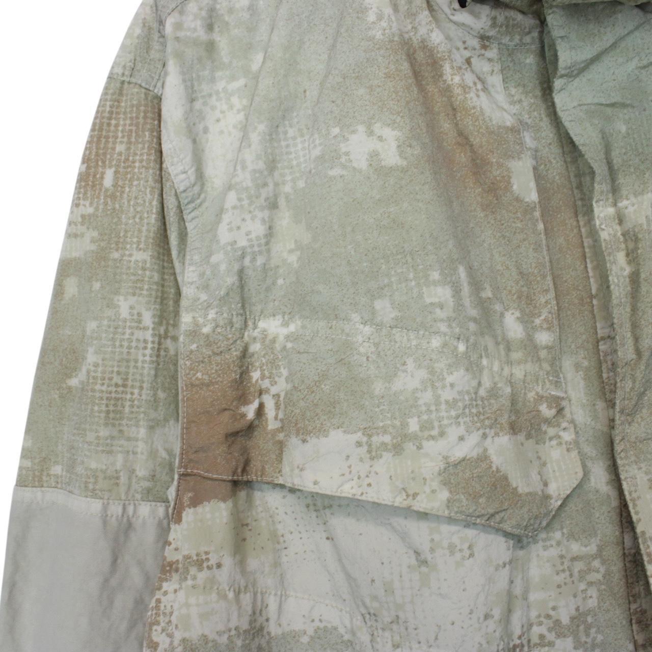 Stone Island green full zip jacket with dissolving grid camo pattern and logo patch.