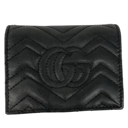 Gucci black calfskin wallet with matelassé pattern and GG logo detail.