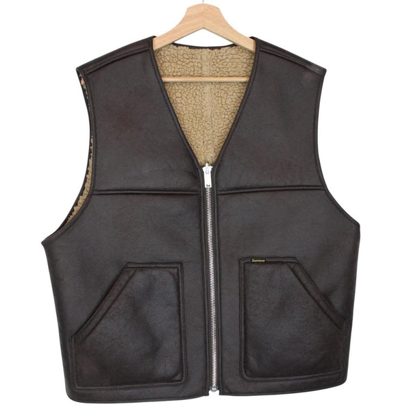Supreme brown reversible faux shearling work vest with logo patch and textured fabric.