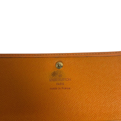 Louis Vuitton orange leather wallet with Epi texture and embossed logo detail.