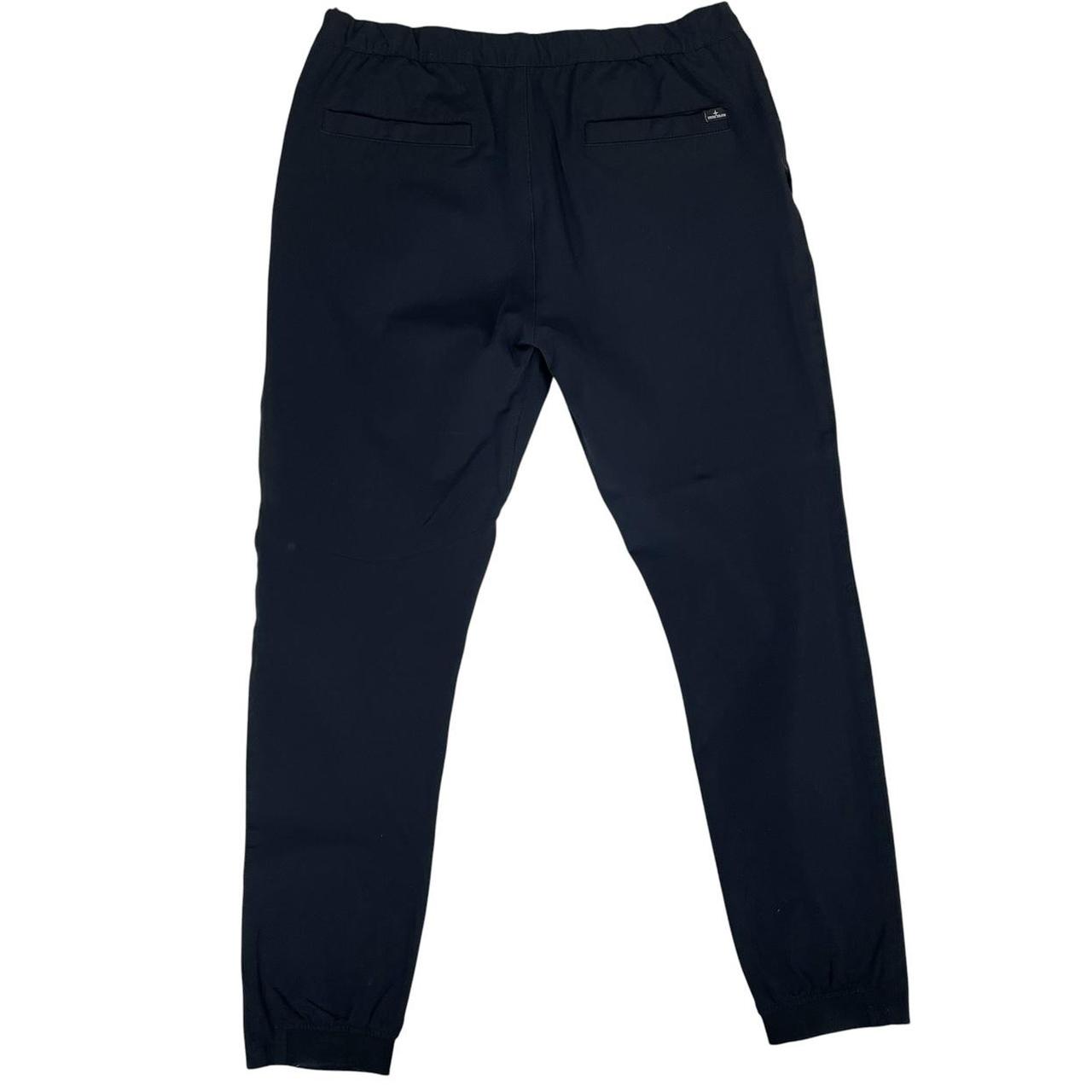 Stone Island navy blue joggers with logo patch and nylon material.