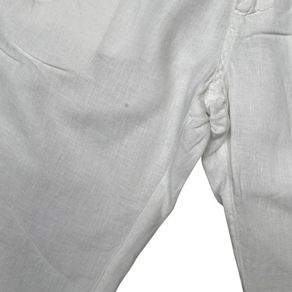 Stone Island white linen Bermuda shorts with logo patch and subtle stains.
