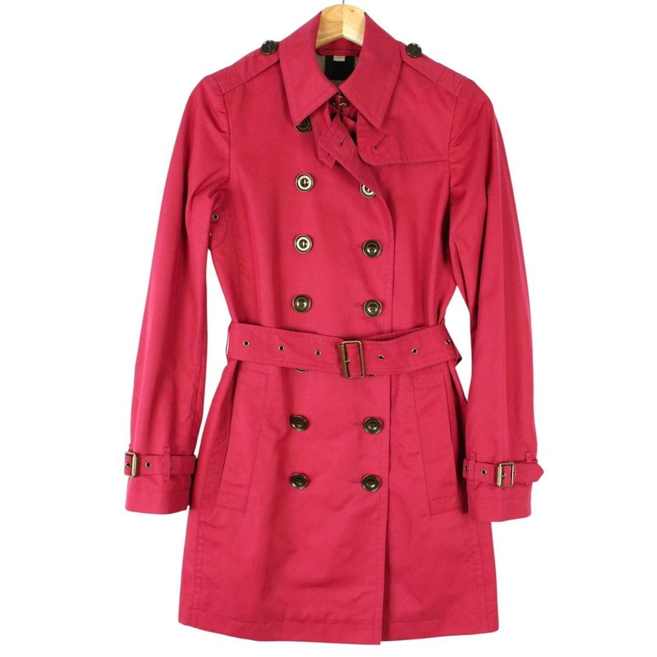 Burberry pink double breasted belted trench coat with classic check lining and logo buttons.